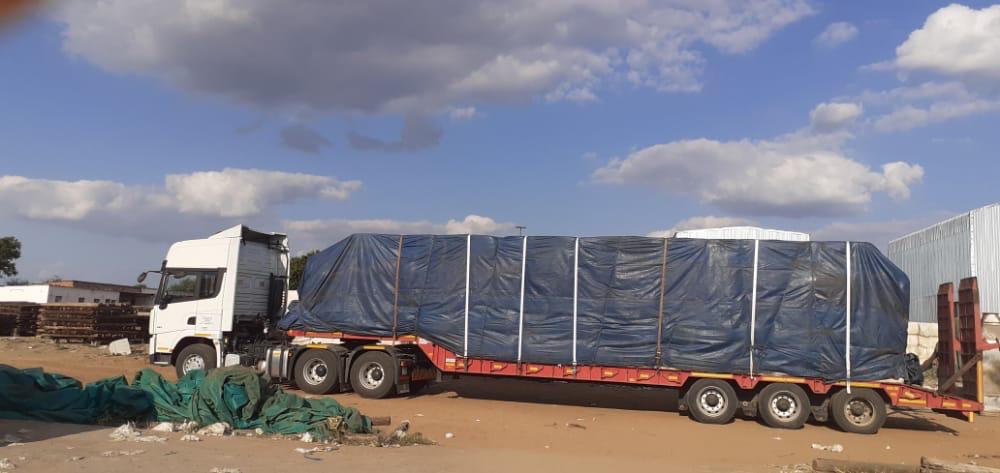 Shacman X3000 horse truck with a tarped load strapped to the lowbed trailer