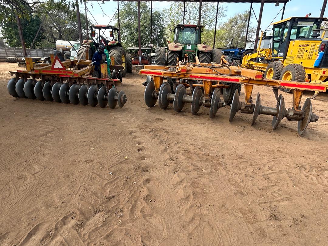 Riptill disc harrows, tractors and grader lined up in the yard