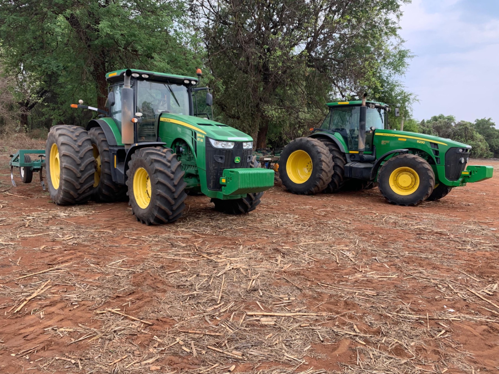 Riptill John Deere 8320R and 8230 tractors with rippers on a cleared land