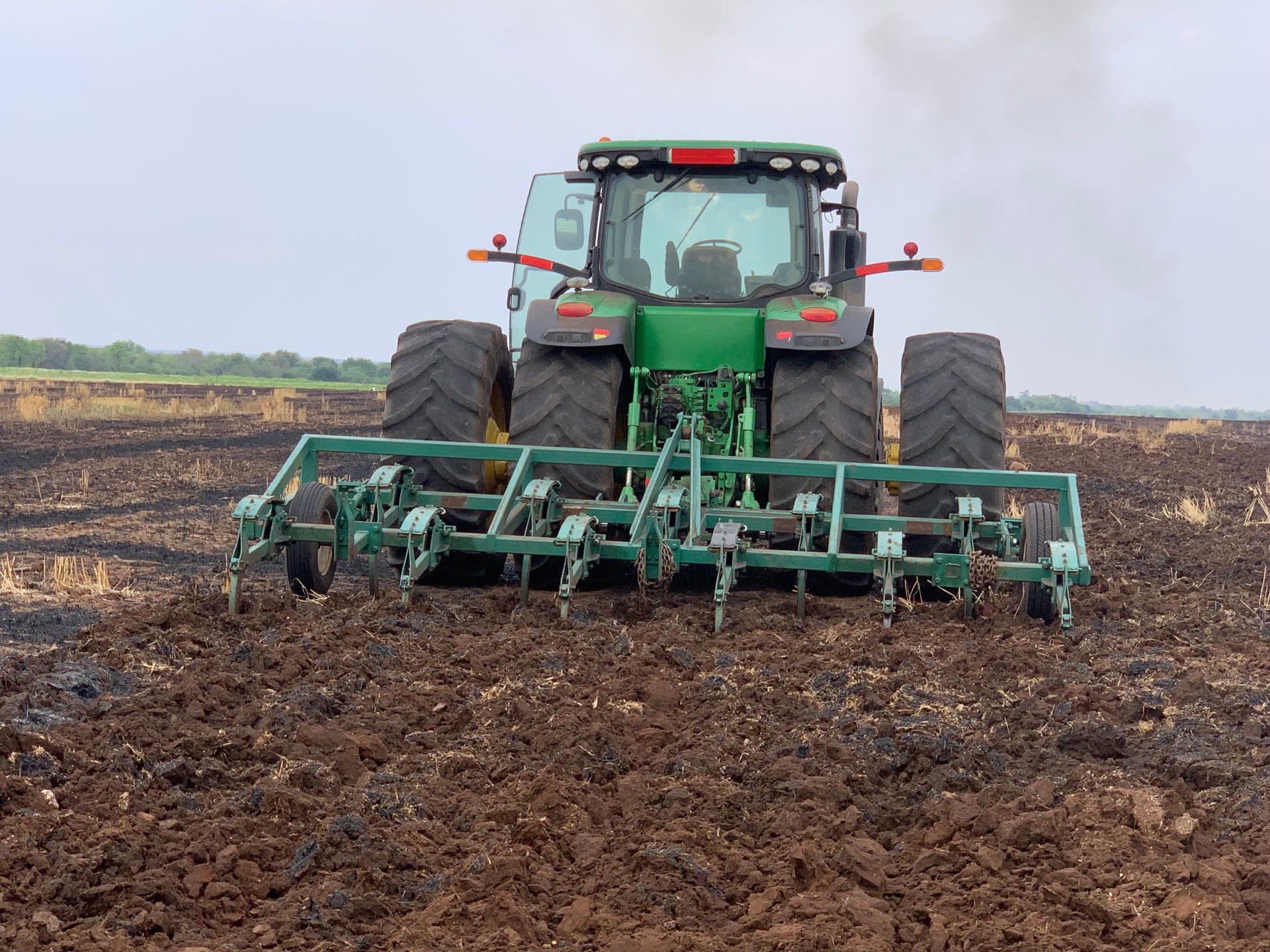 Rear view of a John Deere tractor pulling a wide ripper frame